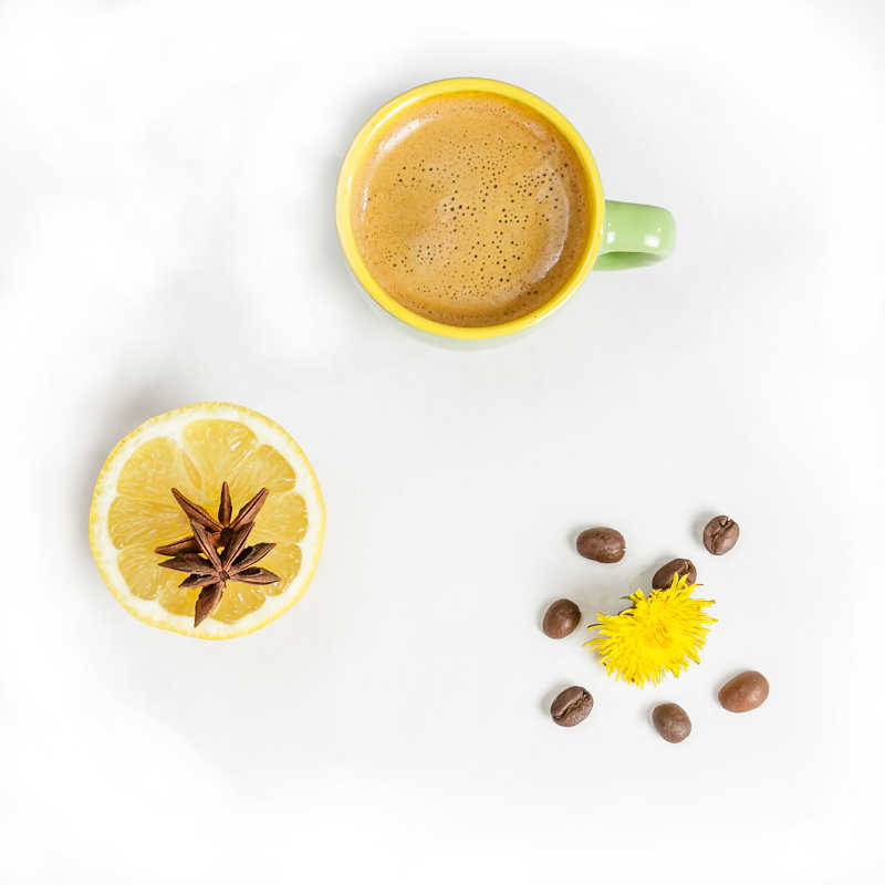 Šálka lahodnej kávy s krémou, citrusmi a kávovými zrnkami